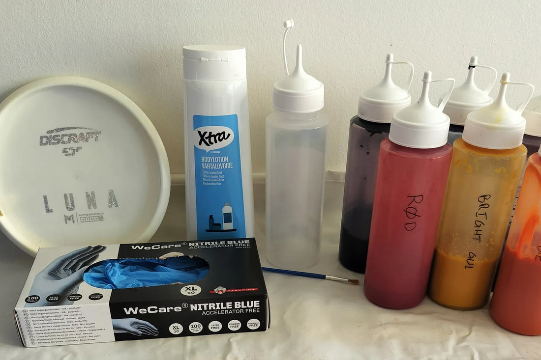 Disc dye kit: a white disc, bottles of dye, gloves and a brush