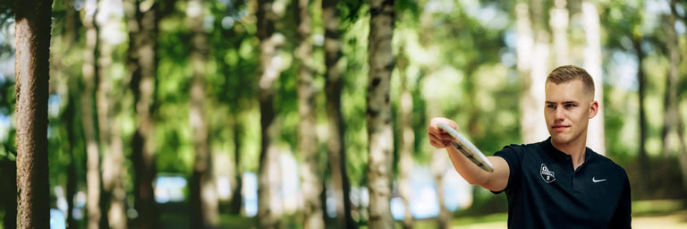 male disc golfer in black polo preparing to throw his disc